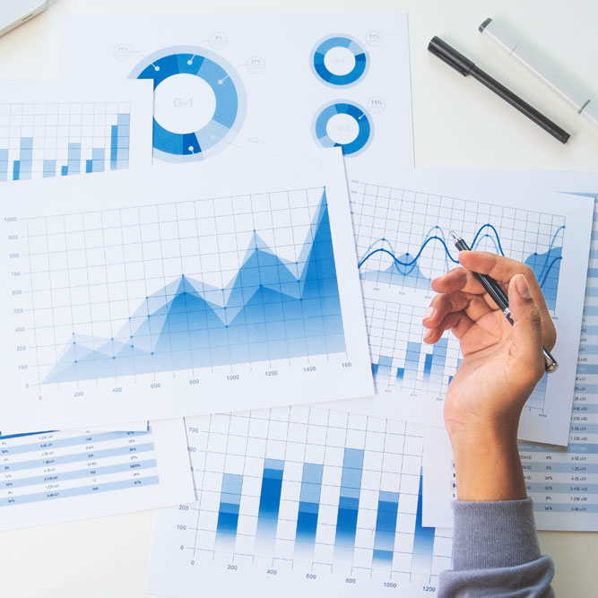 Mano sosteniendo un bolígrafo sobre los informes